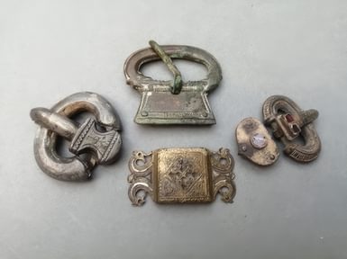 A selection of belt buckles and a gold plated belt slide from Highdown Hill