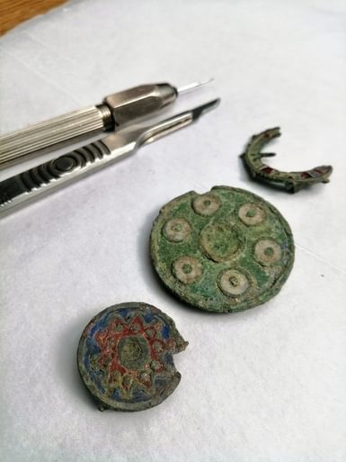 Three round and damaged, Roman copper alloy brooches, all with remains of enamel.